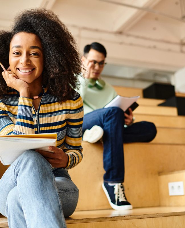 Multicultural students, including African American and Black girl, attentively listen in a university lecture hall.
