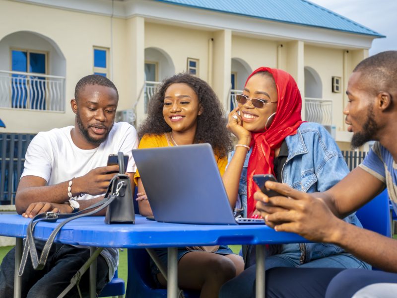A group of young African people hanging out in an outdoor cafe