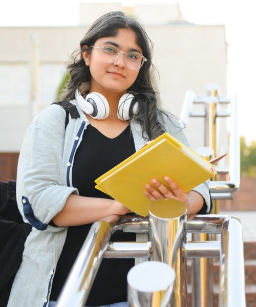 Portrait of Indian girl student with books near university.